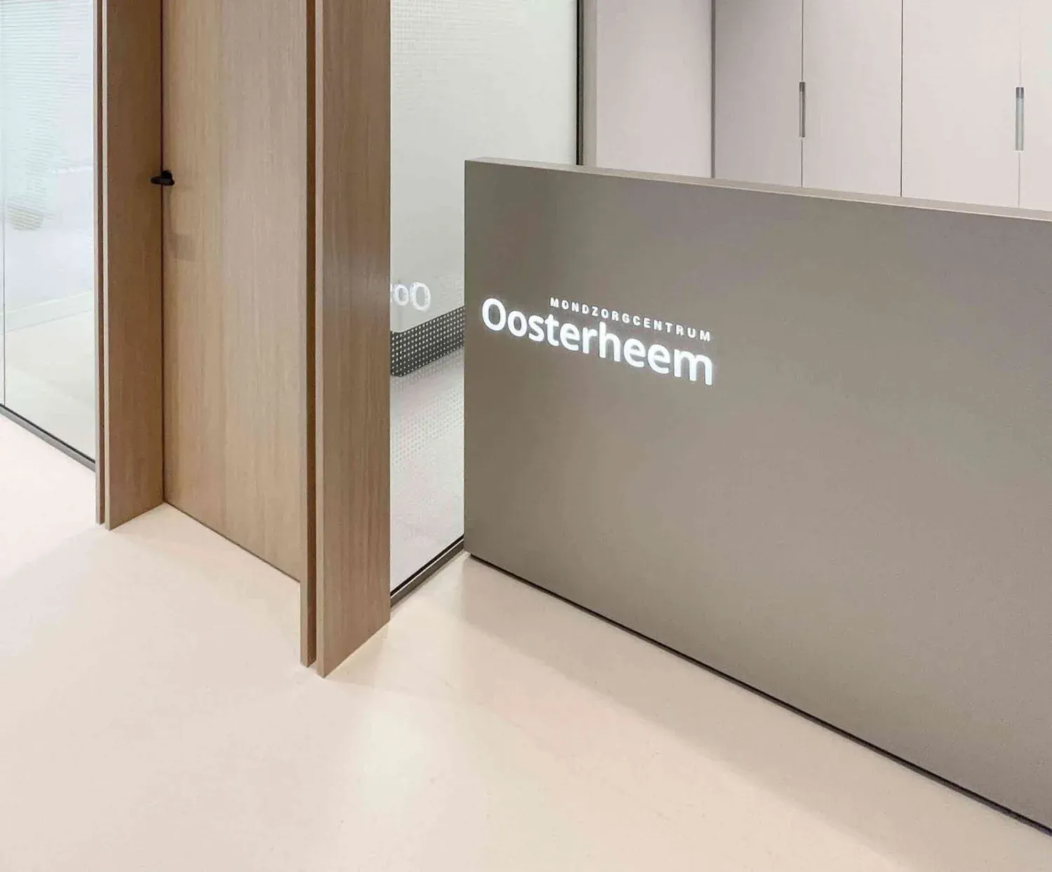 De balie van Mondzorgcentrum Oosterheem, met de verlichte praktijknaam
