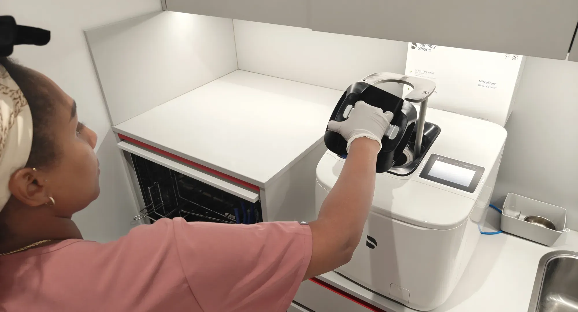 Een assistente vult de sterilisatie-apparatuur in onze sterilisatieruimte: elk instrument doorloopt dezelfde vaste route